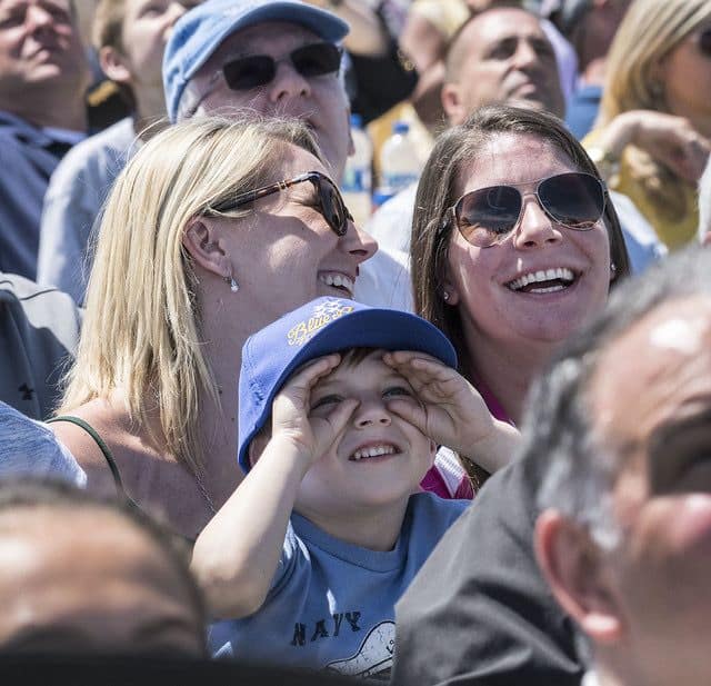 Young child staring up at Blue Angels jets as they fly by